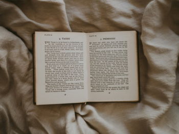 opened book on brown textile