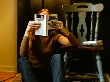 a person sitting on the floor reading a book