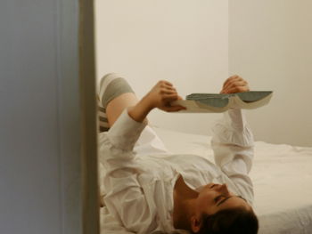 a person laying on a bed with a skateboard